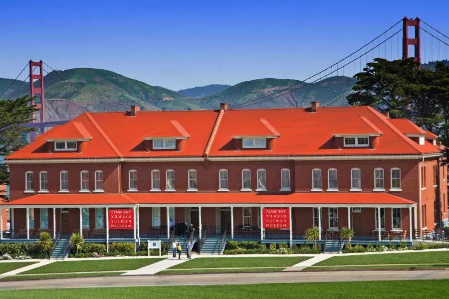 的 Walt Disney Family Museum, housed in a row of red-brick former barracks, st和s in front of the 金门大桥. San Francisco, California.